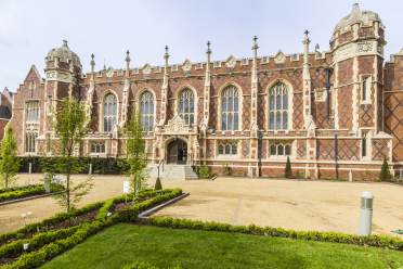 Red-brick mansion with arched windows and stone buttresses