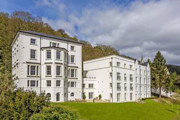 White mansion on wooded hillside