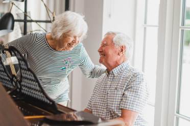 Retired people playing piano and laughing