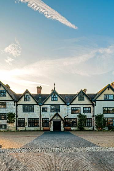 Wrought iron gates and Tudor mansion