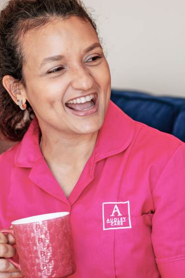 Woman enjoys coffee and chat with carer