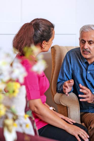 Seated man talking with carer