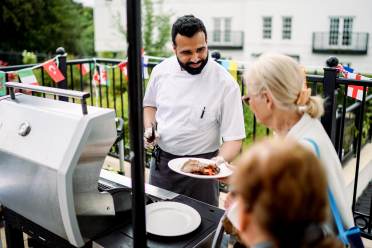 Barbecue with chef handing out cooked food