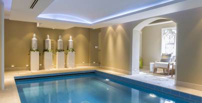 Blue indoor pool in calm surroundings with mood lighting