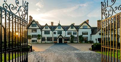 Wrought iron gates and Tudor mansion