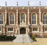 Red-brick mansion with arched windows and stone buttresses