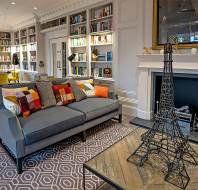 Bookshelves, large fireside sofa and Eiffel tower decoration