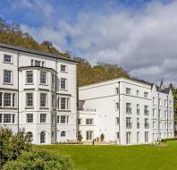 White mansion on wooded hillside