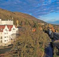 Grand white buildings on wooded hillside