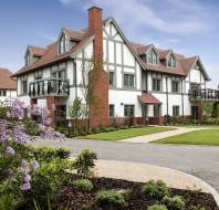 Apartment block with hip roof and faux-timbered design