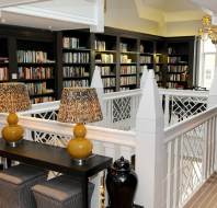 Dark bookshelves and white wooden stairway