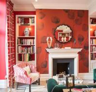 Red and coral decorated library with green armchairs