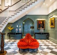 Reception area with chess tiled floor, coral seat and staircase