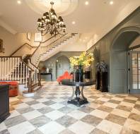 Reception area with chess tiles on the floor, chandelier and luxury decor