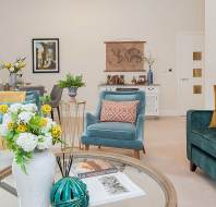 Living room with teal furniture and round glass coffee table