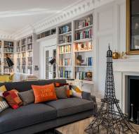 Large sofa, Eiffel Tower decoration and large fireplace.