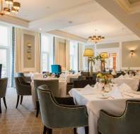 Tables set for service in restaurant with high ceiling