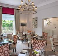 Restaurant tables below large chandelier