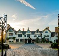 Wrought iron gates and Tudor mansion