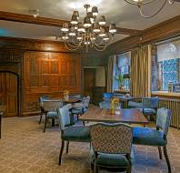 Tudor style restaurant interior with alabaster chairs and 4 seat square tables