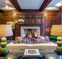 Lounge with large fireplace and wood panelling