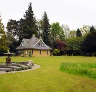 Cottage and fountain in landscaped grounds