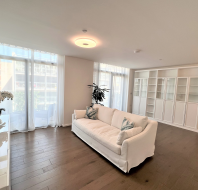 Large living room with wood floor and picture windows