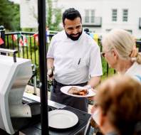 Barbecue with chef handing out cooked food