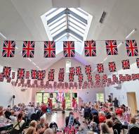 Guests watch singing trio in long room with Union Jacks
