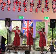 Singing trio in polkadot dresses with Union Jack bunting