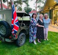 Three guests standing by Jeep with Union Jack