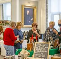 Shoppers gathered around stall in grand Georgian-style room