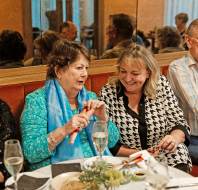 Guests enjoying Christmas crackers and wine