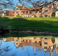 Manor house reflected in still lake