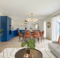Modern living room and kitchen area with a blue and white kitchen, orange chairs, and a round chandelier. A sofa, coffee table, and plant are in the foreground near large windows.