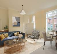 A modern living room with a blue sofa, a patterned armchair, a marble coffee table, and a dining area. Large windows let in natural light.