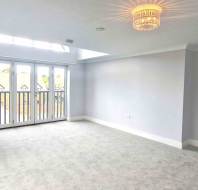 A room with a chandelier and a glass door.