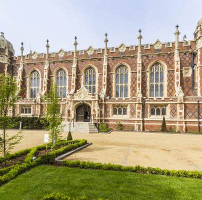 Red-brick mansion with arched windows and stone buttresses