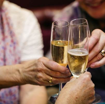 Senior ladies cheering with Champagne