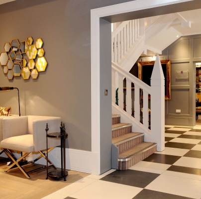 Entrance hall with staircase, seating and chequerboard floor