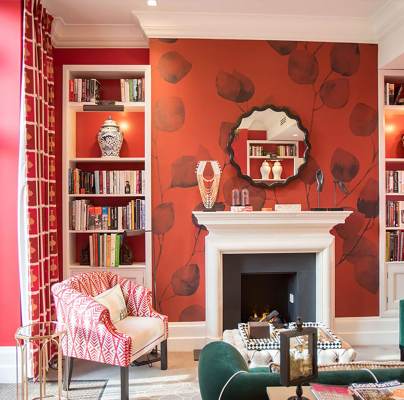 Red and coral decorated library with green armchairs