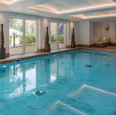 Indoor pool with loungers and large windows