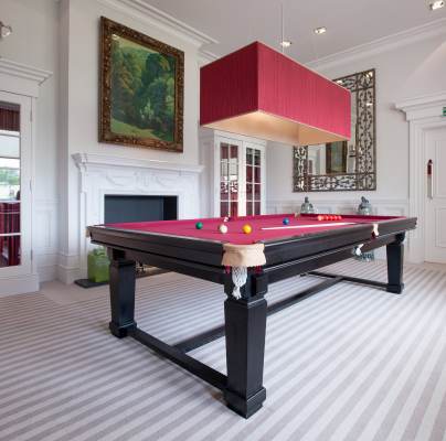 Red baize billiard table in a cozy room