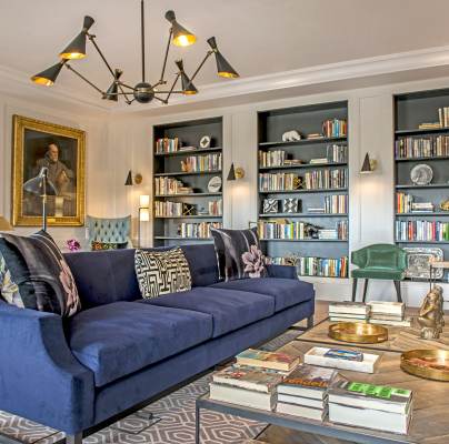 Long blue sofa, book shelves and painting