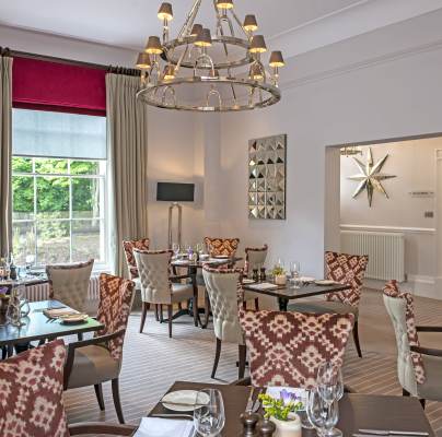 Restaurant tables below large chandelier