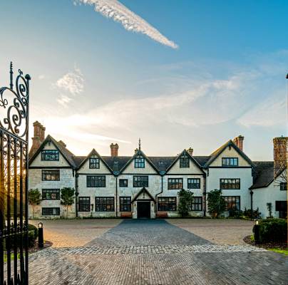 Wrought iron gates and Tudor mansion