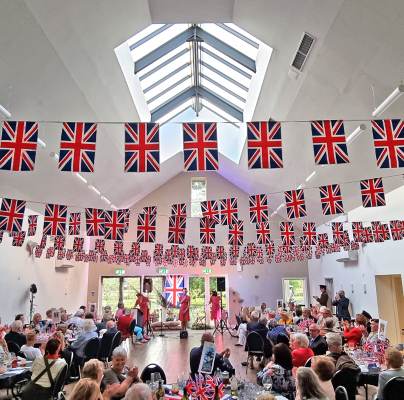 Guests watch singing trio in long room with Union Jacks