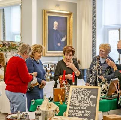 Shoppers gathered around stall in grand Georgian-style room