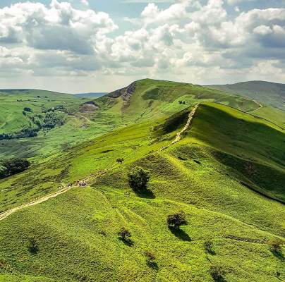 A broad footpath along a grassy mountain ridge