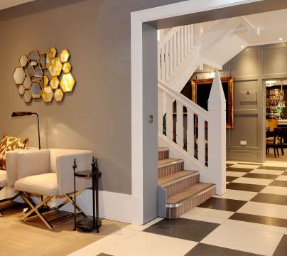 Entrance hall with staircase, seating and chequerboard floor